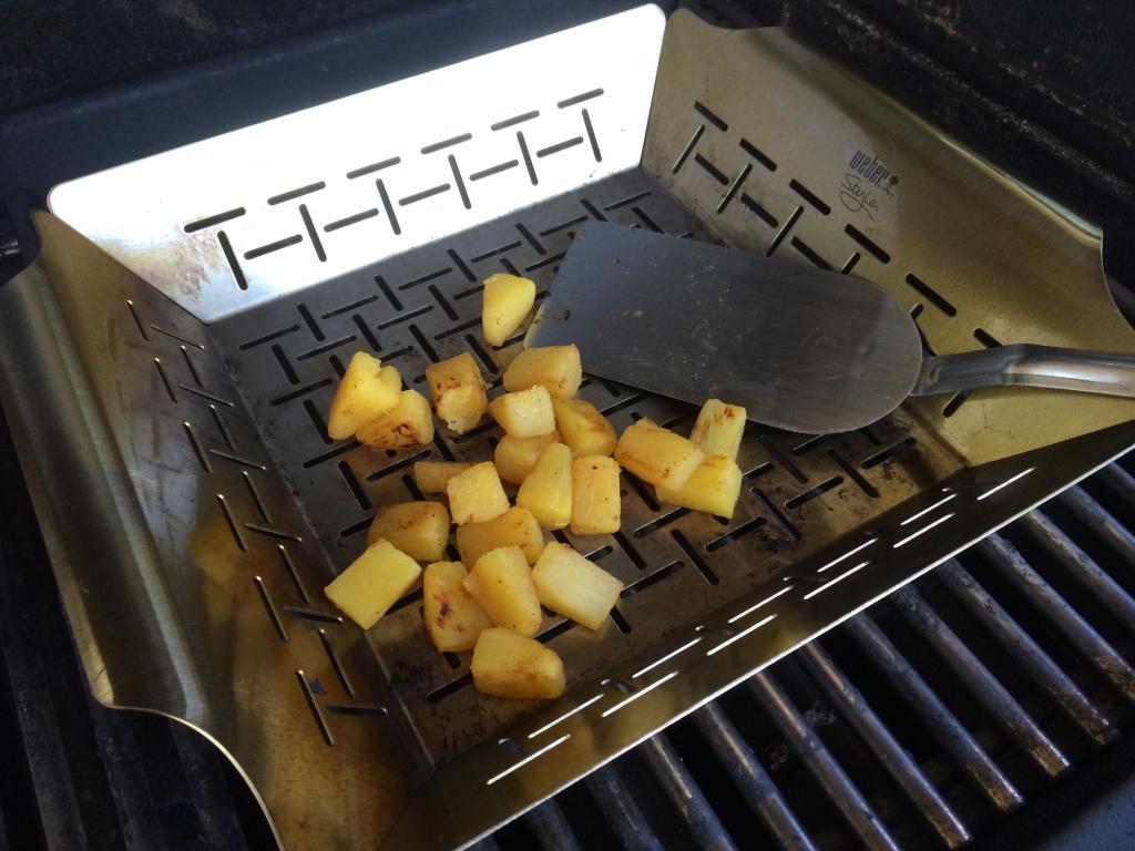 Grilling pineapple chunks in the basket
