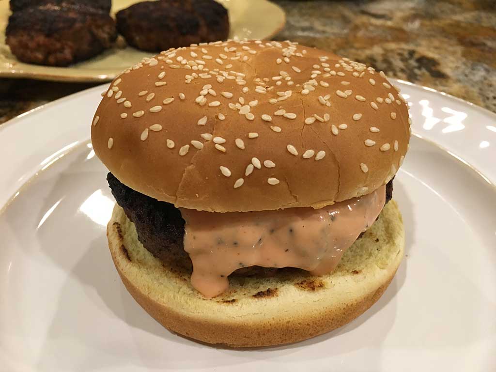 Meatloaf burger on toasted sesame seed bun with burger sauce