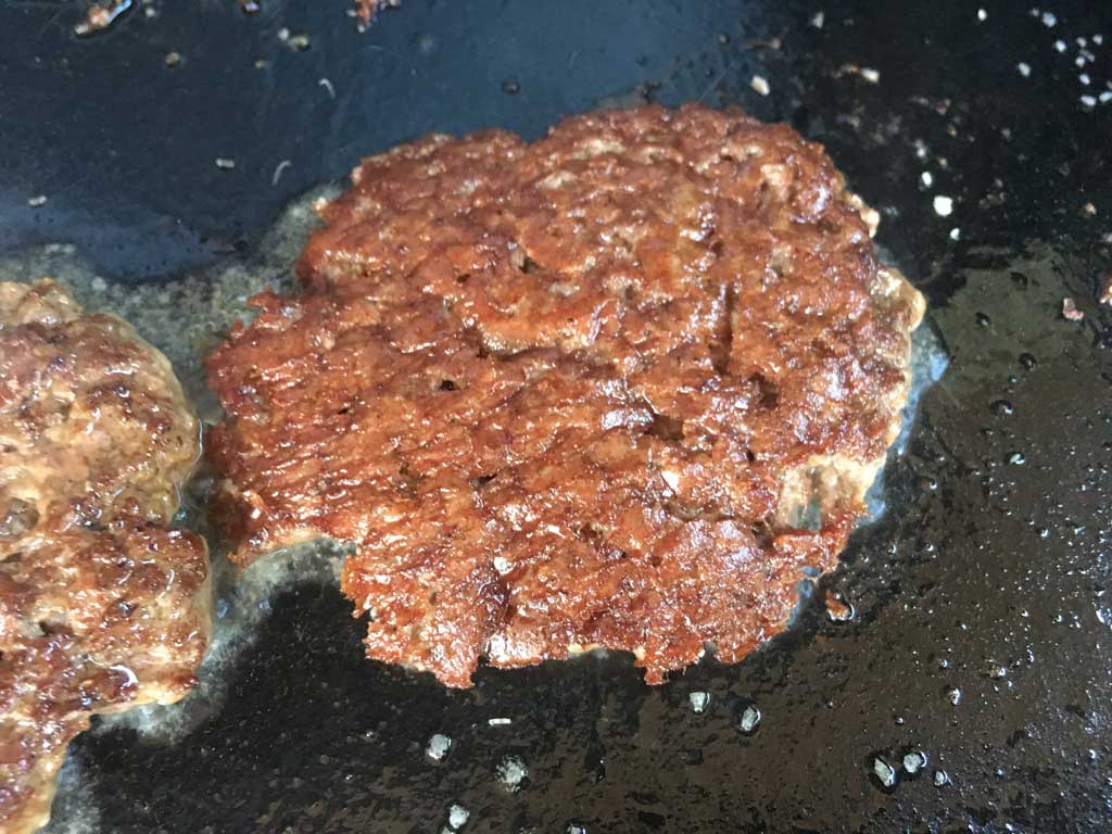 Close-up of crust on flipped burger patty
