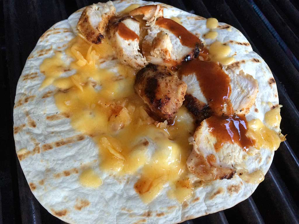 Chunks of chicken breast and barbecue sauce added to the tortilla
