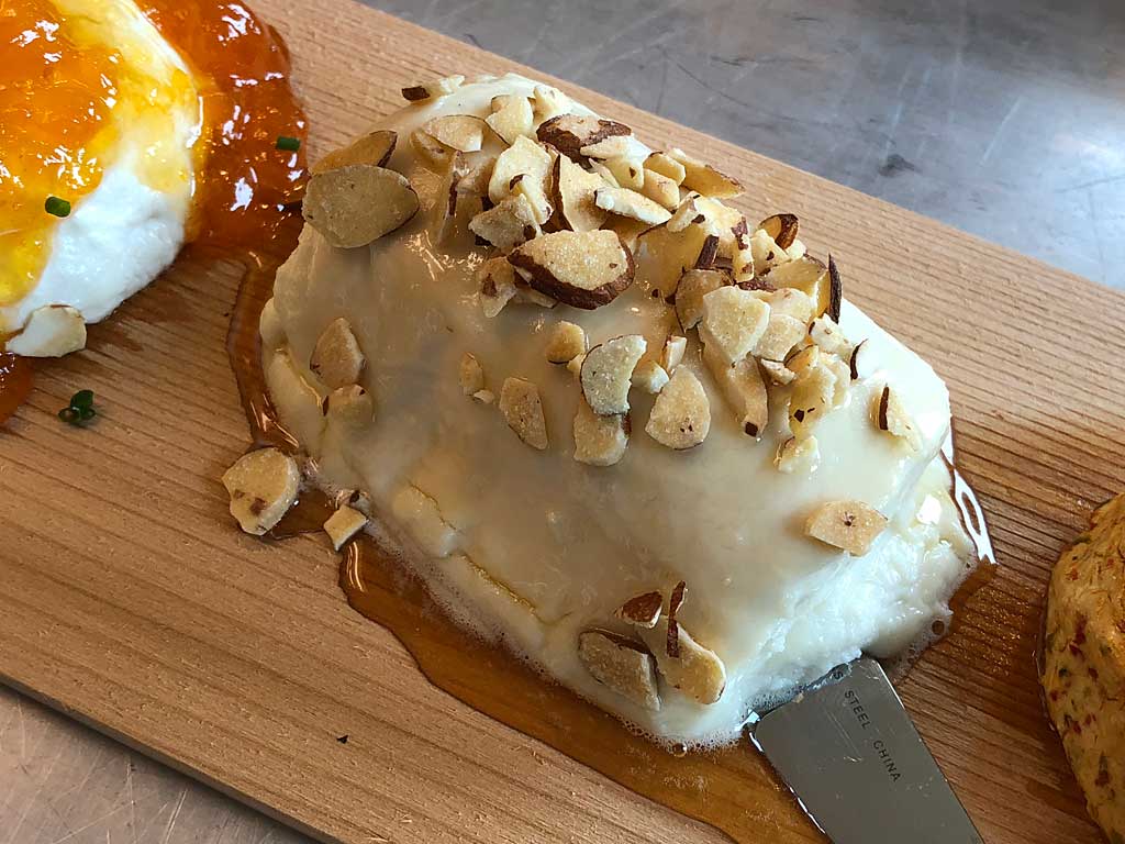 Laura Chanel's Honey Goat Cheese Log with drizzled clover honey and sliced almonds