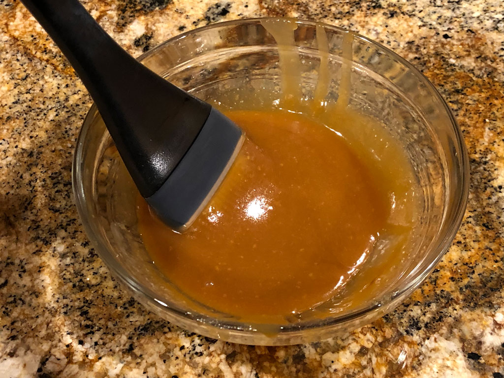 Pomegranate molasses glaze in mixing bowl with basting brush