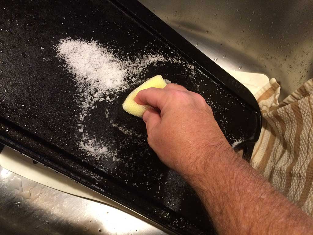 Using a Dobie scrubber and kosher salt to remove stubborn bits.