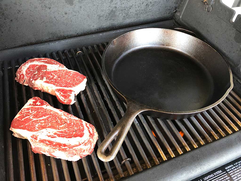 Ribeye steaks on cool side of grill