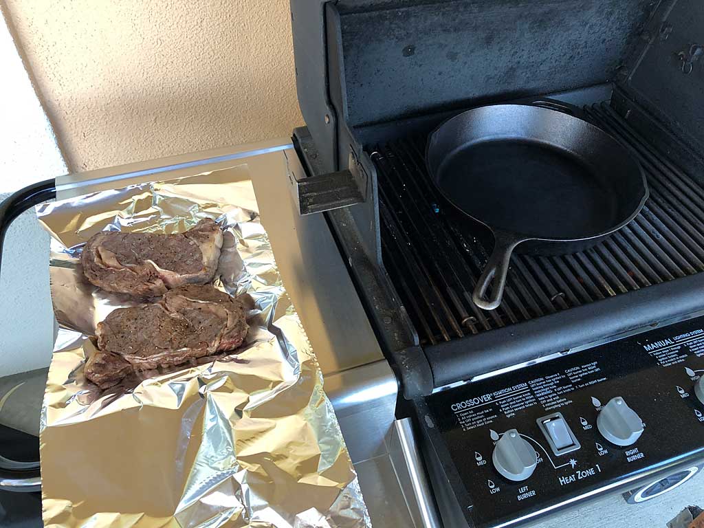 Steaks removed from grill while skillet heats up