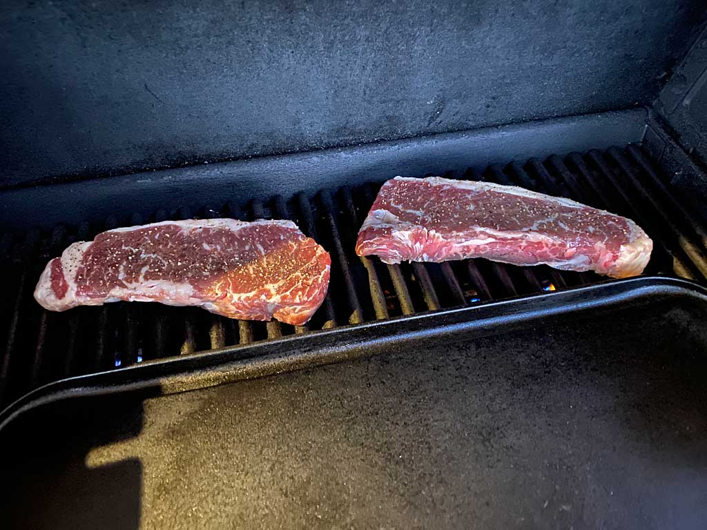 Creekstone Farms NY strip steaks grilling indirect before the reverse sear
