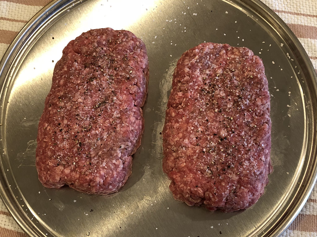 Two 3/4 pounds ground chuck patties with salt and pepper