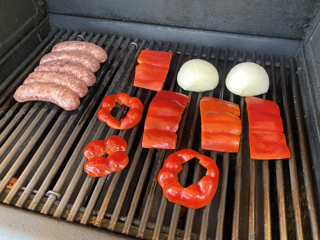 Brats and veggies go on the gas grill